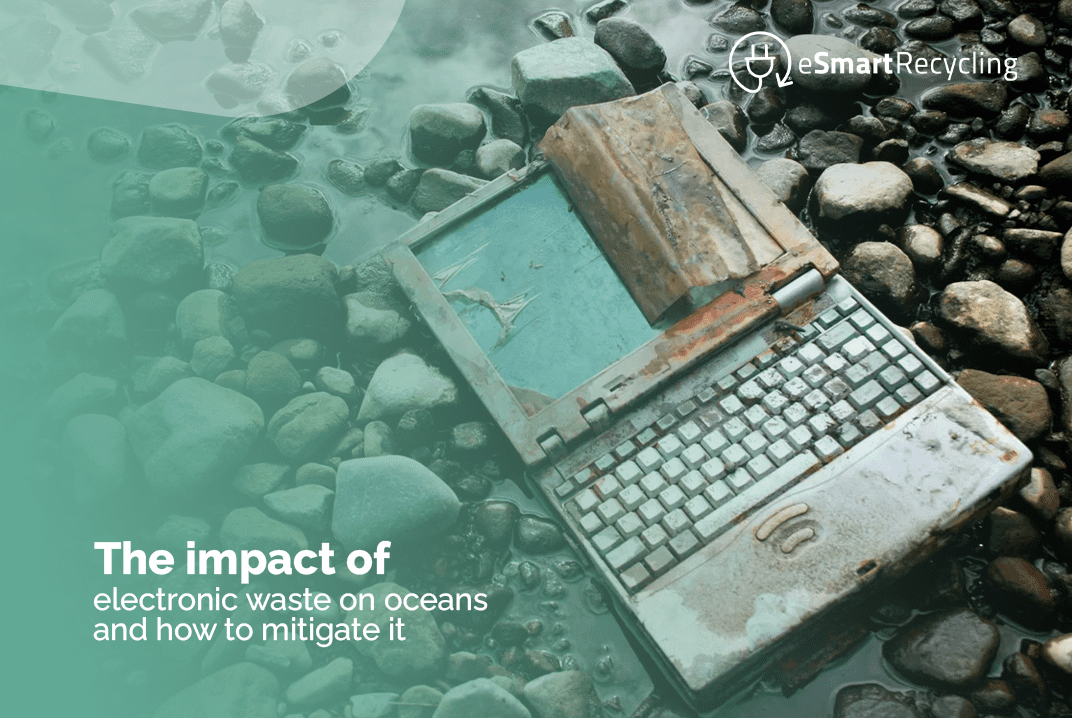 An old, rusted laptop discarded among rocks in a body of water, illustrating the environmental impact of electronic waste on oceans. The eSmart Recycling logo is present in the upper right corner. Text overlay reads: 'The impact of electronic waste on oceans and how to mitigate it